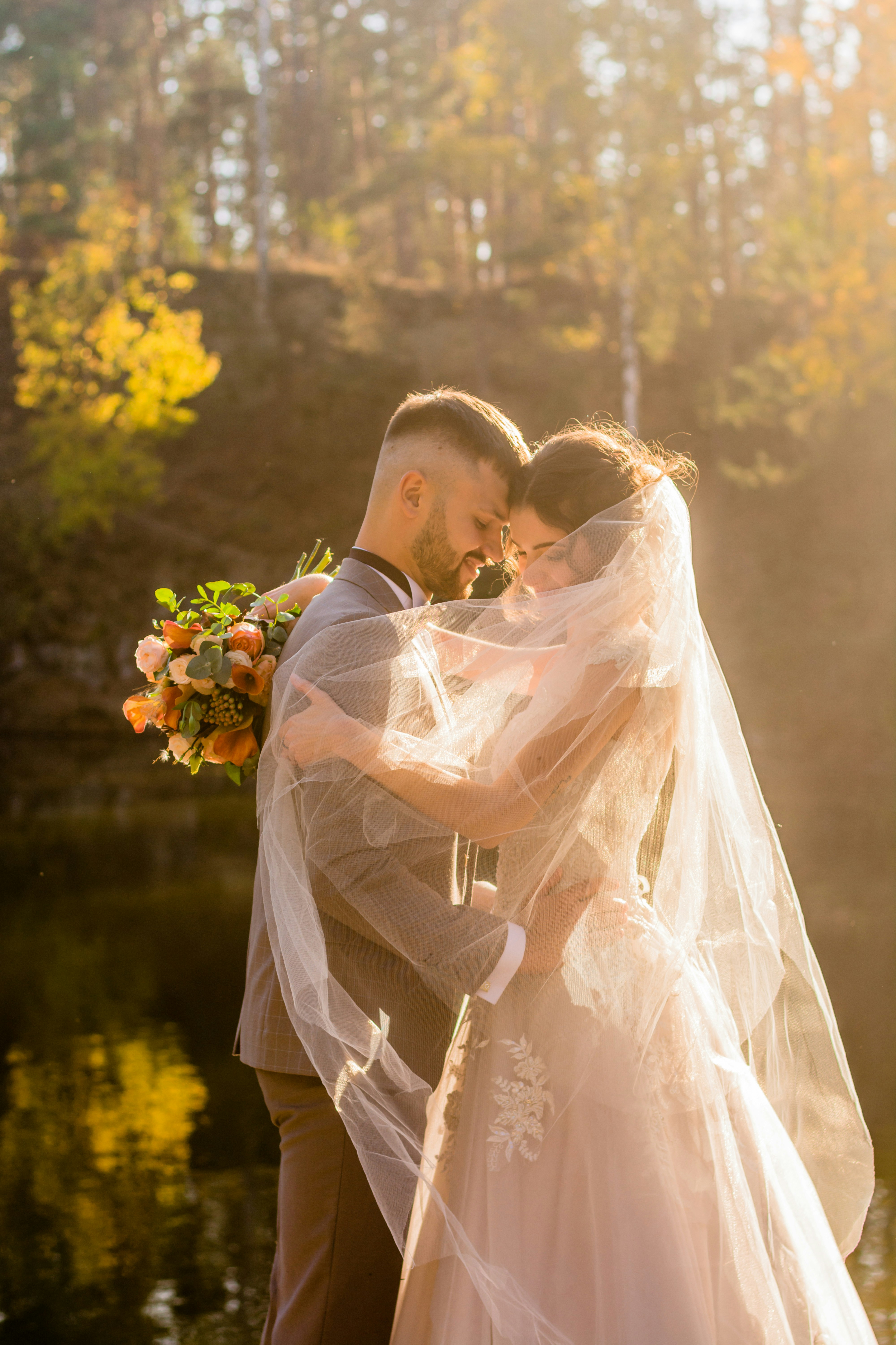 Romantic wedding couple embracing at sunset